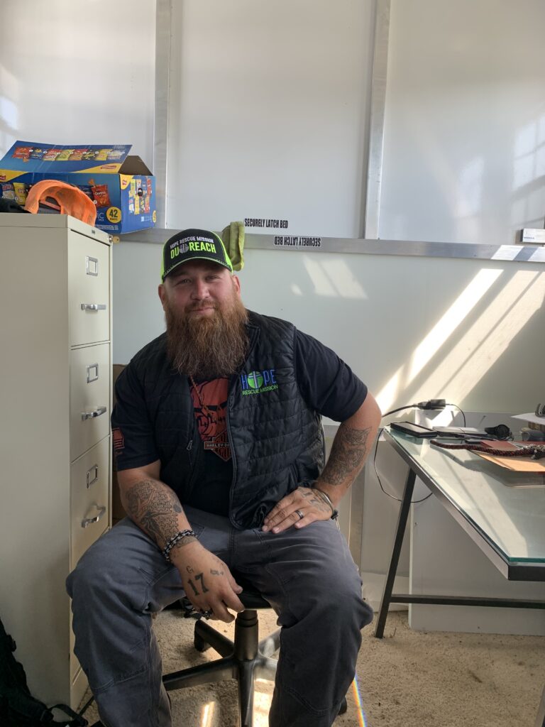 Guy Johnson, a peer support counselor, sits in the office at the Temporary Safe Outdoor Space