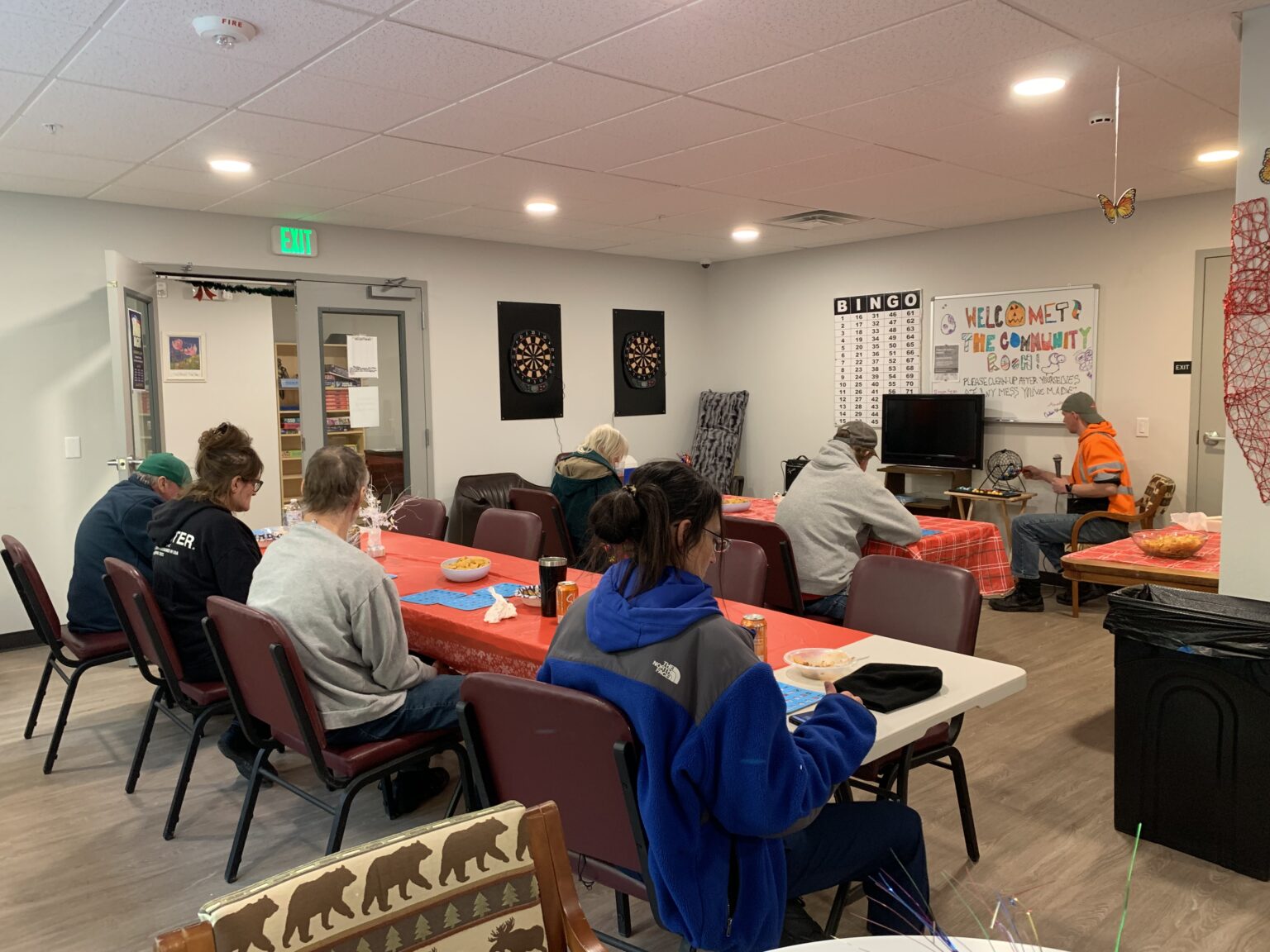 people sit at a bingo game in the community room