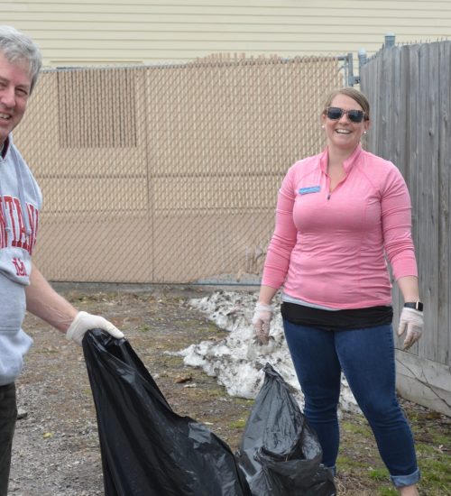 Staff members smile while cleaning up
